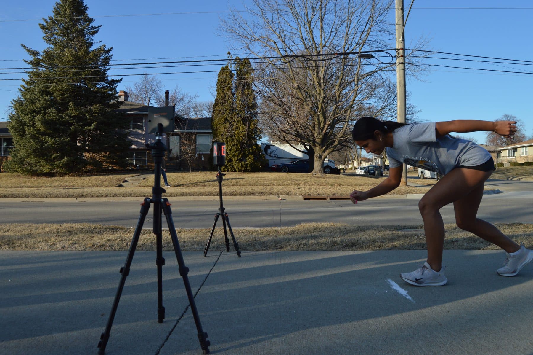 An athlete starts a sprint between outdoor timing gates.