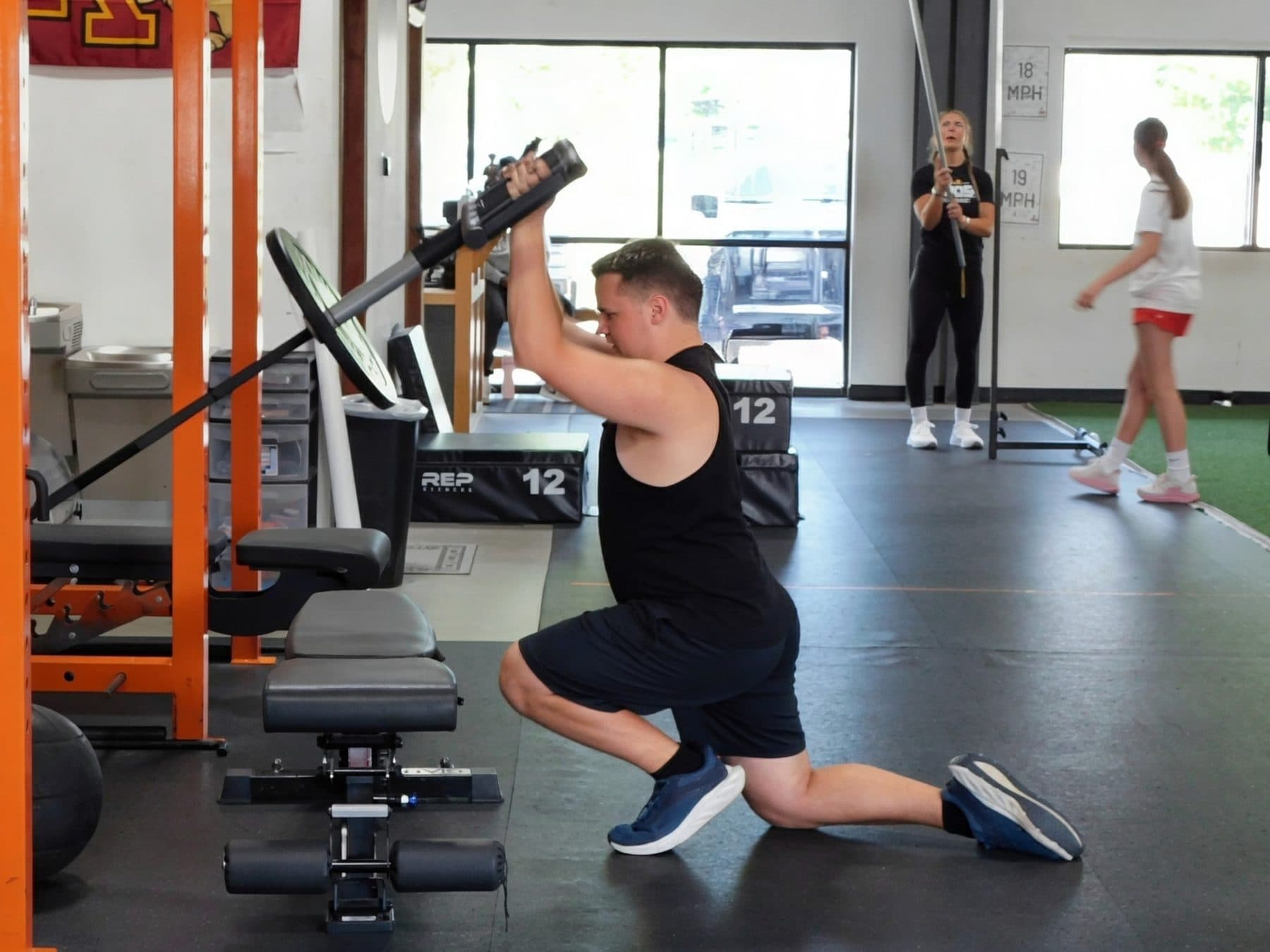 An athlete performs a half-kneeling landmine press.