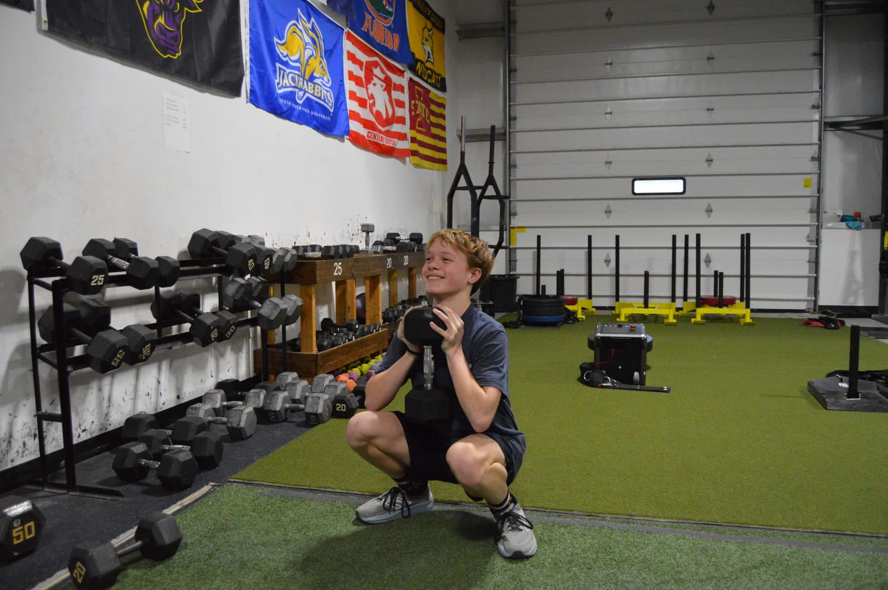 An athlete holds a goblet squat on the turf at Jarosh Performance.
