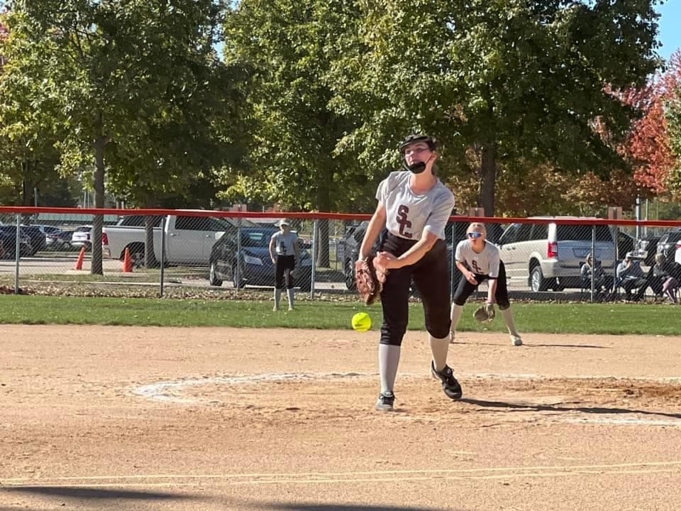 A softball pitcher follows through during a game.