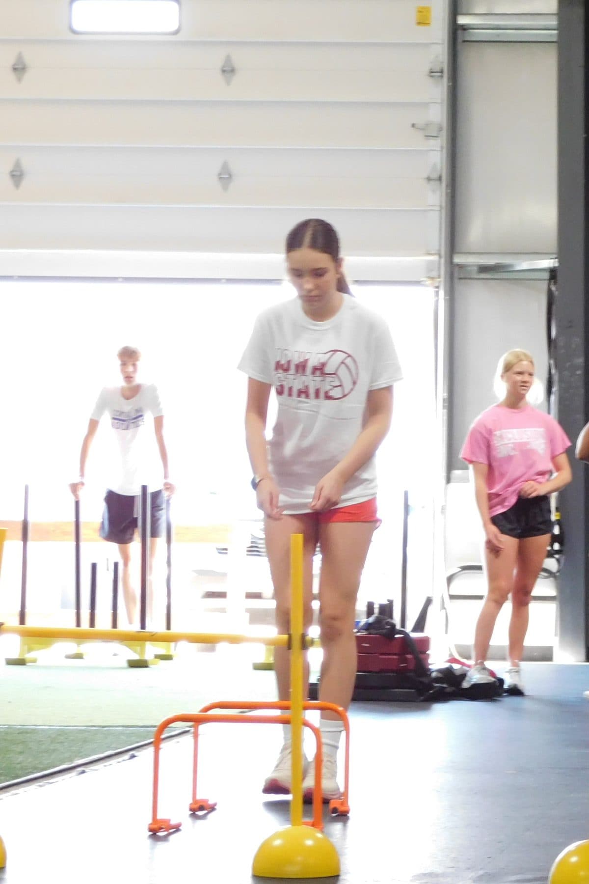 An athlete steps through a hurdle drill during training at Jarosh Performance.